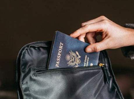 A person puts a passport in their bag.