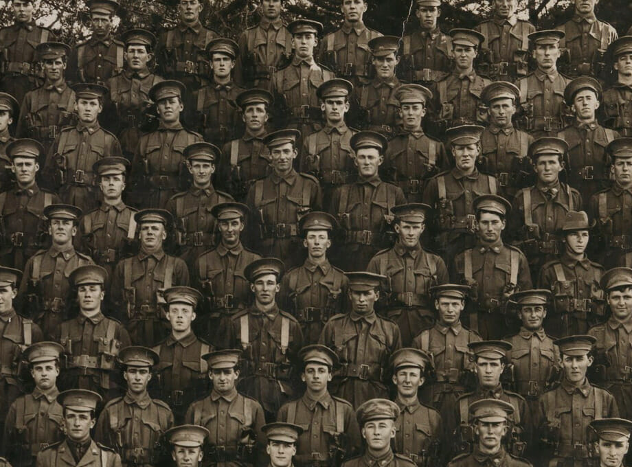 An old photo of about 50, posed military members in uniform.