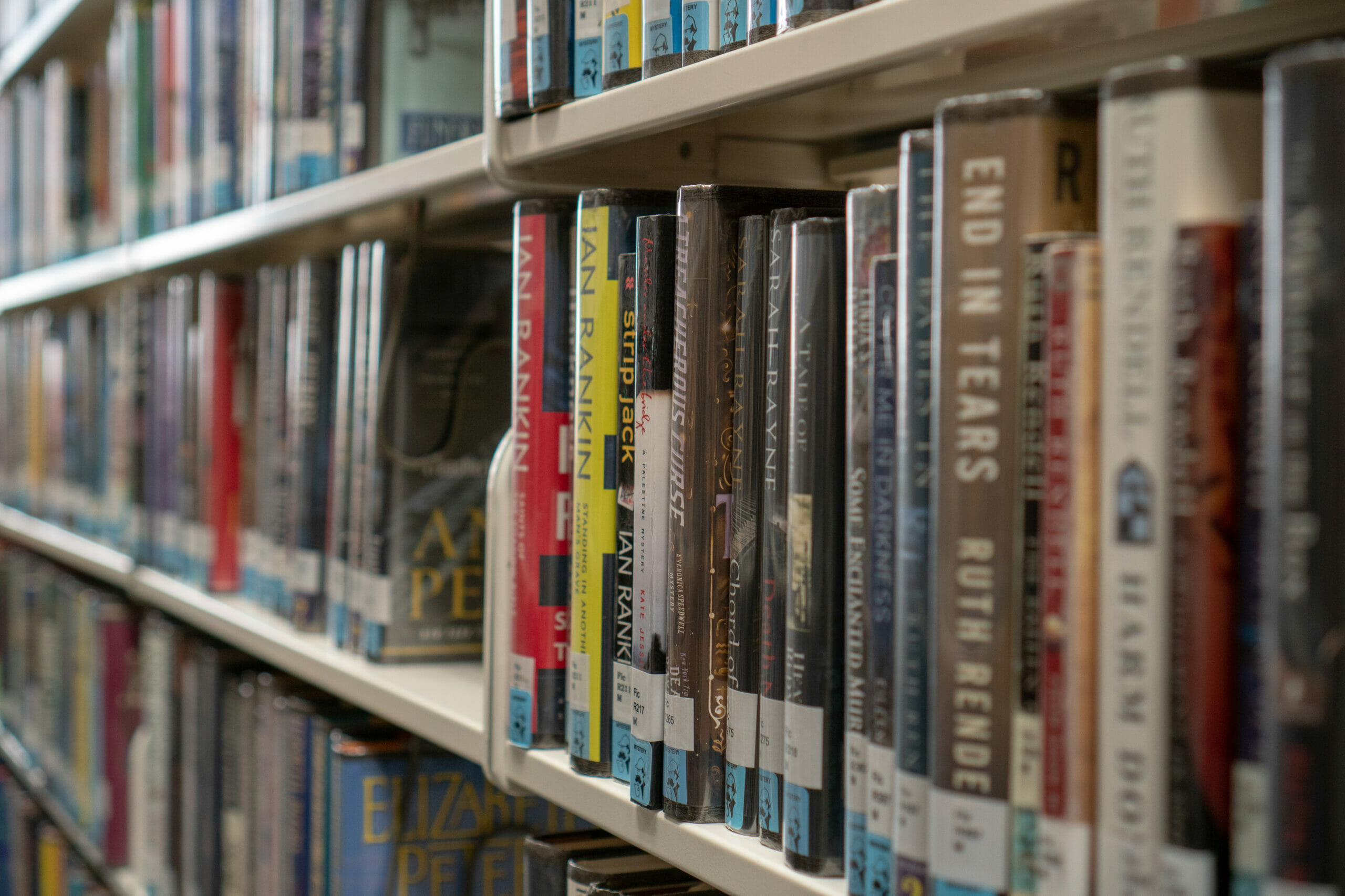 A close up shot of several shelves of hardcover books.