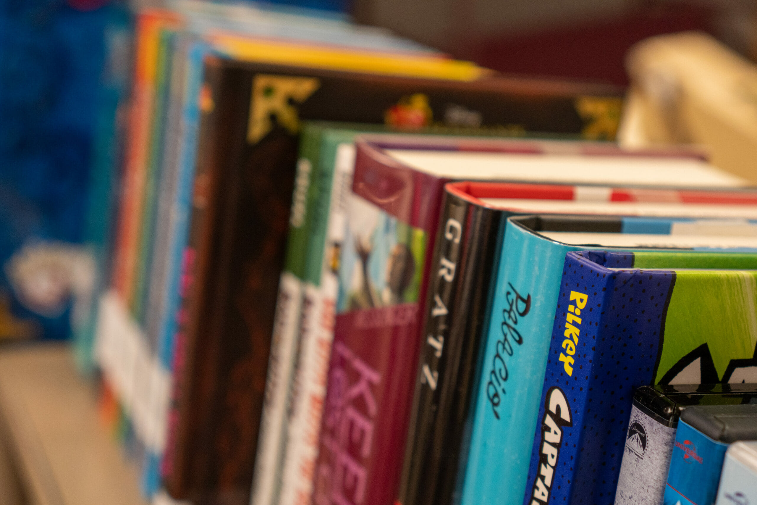 A close up shot of a row of books on a shelf.