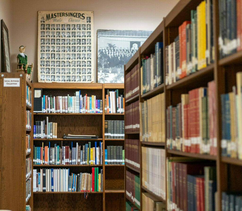 Bookshelves in the Sherman Room at the Main Library with old photos on display.