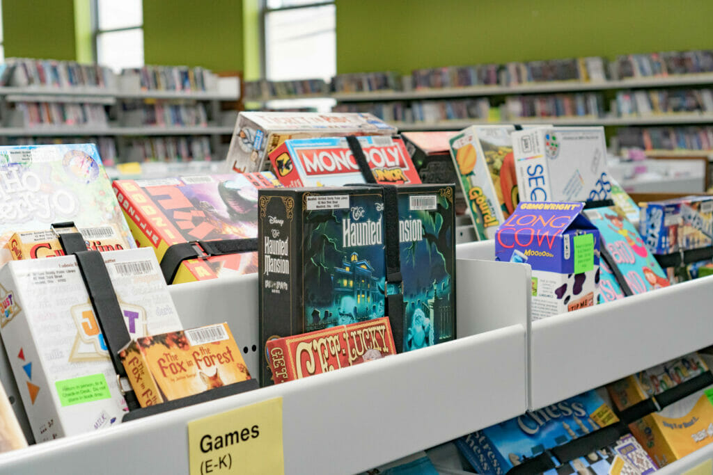 A close-up of a collection of board and card games in their display case at the Main Library.
