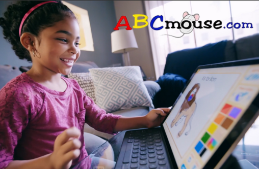 Child plays computer game in living area of a house.