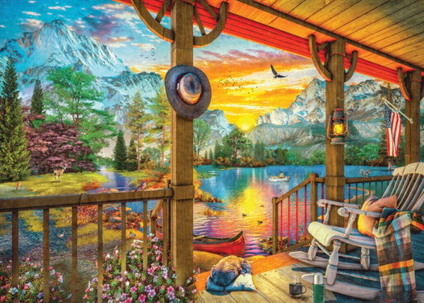 Front porch of a cabin looking our over a fishing pond with mountains in the sunrise and lake view