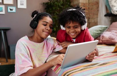Kids watching a video on an Ipad while wearing headphones